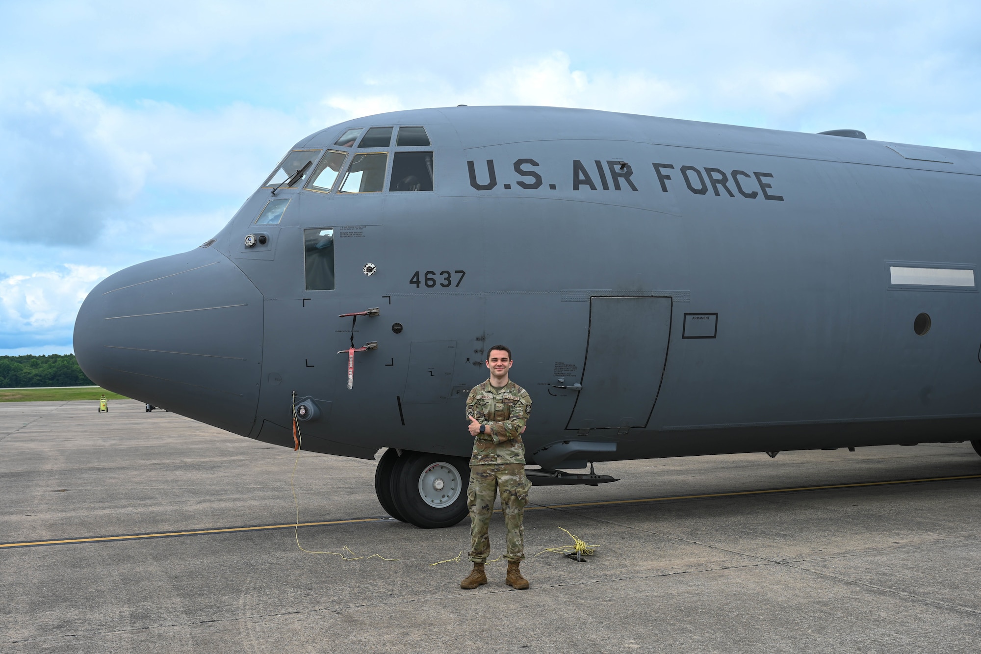 Man poses in front of plane.