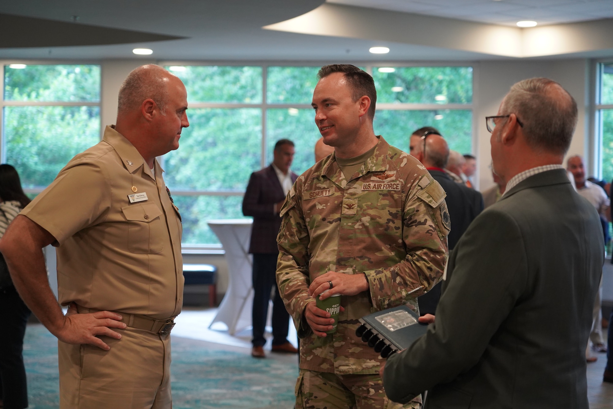 U.S. Air Force Col. Clayton Schuety, 1st Special Operations Wing deputy commander, right, talks with U.S. Navy Capt. Ted Elkins, Naval Air Station Whiting Field commanding officer, left, at the Northwest Florida Defense Coalition’s Tri-State Military Mission Forum in Pensacola, Florida, May 27, 2026.