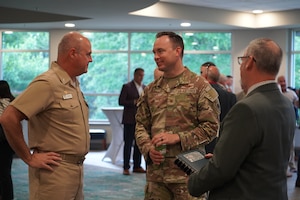 U.S. Air Force Col. Clayton Schuety, 1st Special Operations Wing deputy commander, right, talks with U.S. Navy Capt. Ted Elkins, Naval Air Station Whiting Field commanding officer, left, at the Northwest Florida Defense Coalition’s Tri-State Military Mission Forum in Pensacola, Florida, May 27, 2026.