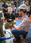 James Calverley, a senior mechanical engineer at Puget Sound Naval Shipyard and Intermediate Maintenance Facility (PSNS & IMF), demonstrates the auto-hydrolance condenser cleaning robot to Rear Adm. Jason Lloyd, then-chief engineer (CHENG) of Naval Sea Systems Command (NAVSEA) 05.