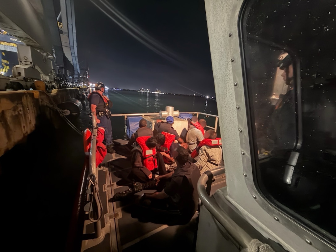 A Coast Guard Station San Juan boat crew oversees a group of eight stowaway aliens apprehended moments earlier aboard the Charlotte Bridge barge as it was being towed into San Juan Harbor, May 22, 2026. The apprehended stowaways were transferred to Customs and Border Protection San Juan Field Office personnel for further processing. This apprehension is part of the Homeland Security Task Force (HSTF) initiative established by Executive Order.  The HSTF is a whole-of-government partnership dedicated to eliminating criminal cartels, foreign gangs, transnational criminal organizations, and human smuggling and trafficking rings operating in the United States and abroad. (U.S. Coast Guard photo)