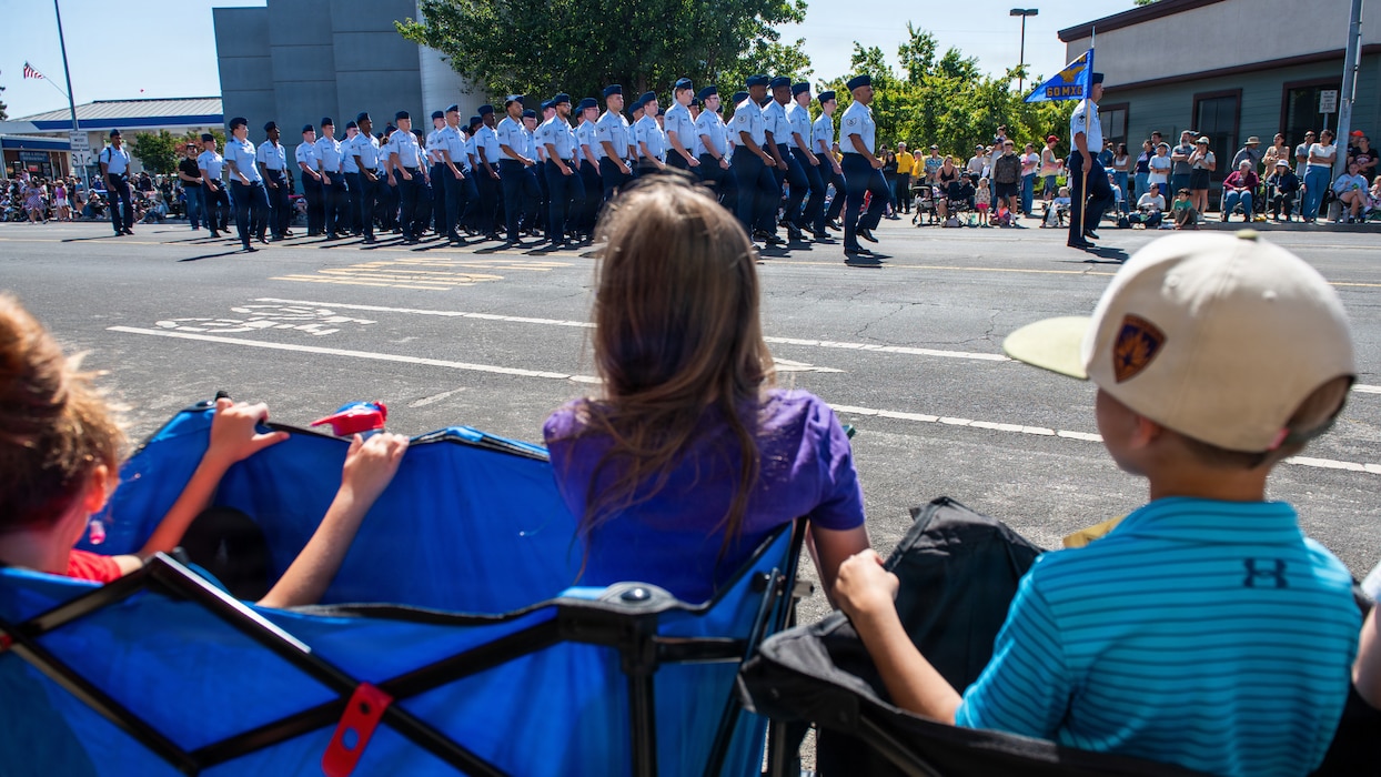 Crowd watch Airmen march in formation in parade
