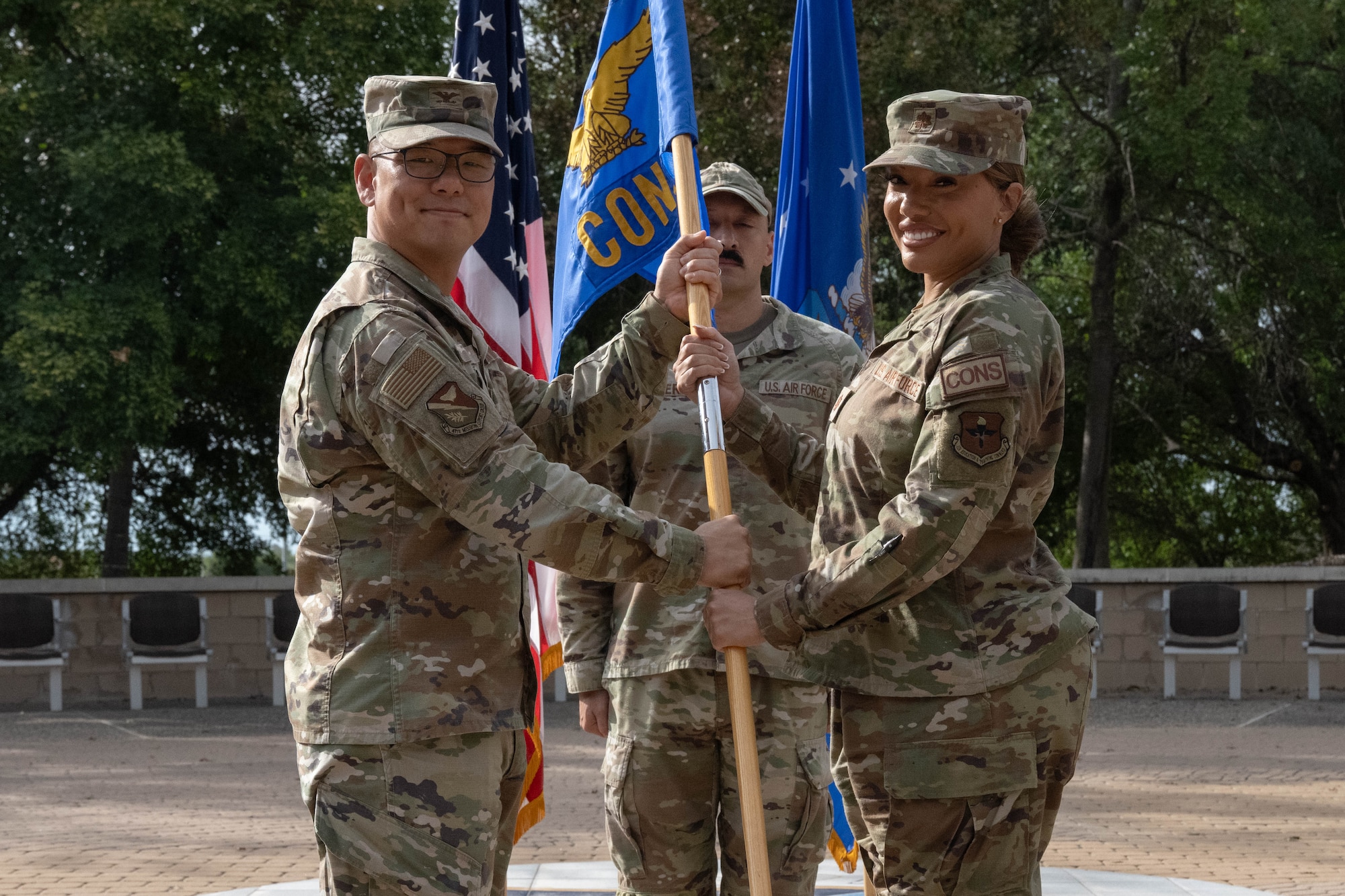 U.S. Air Force Col. Peter Joo, 47th Mission Support Group commander, left, presents the squadron guidon to Maj. Vanessa Valente, incoming 47th Contracting Squadron (CONS) commander, during the 47th CONS change of command ceremony at Laughlin Air Force Base, Texas, May 27, 2026. In a change of command ceremony, the guidon symbolizes the transfer of command, as well as the authority and responsibility associated with it. (U.S. Air Force photo by Airman 1st Class Darryl Keith)