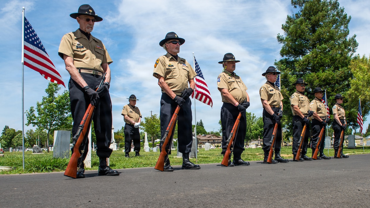 Honor guard members stand by to render rifle salute