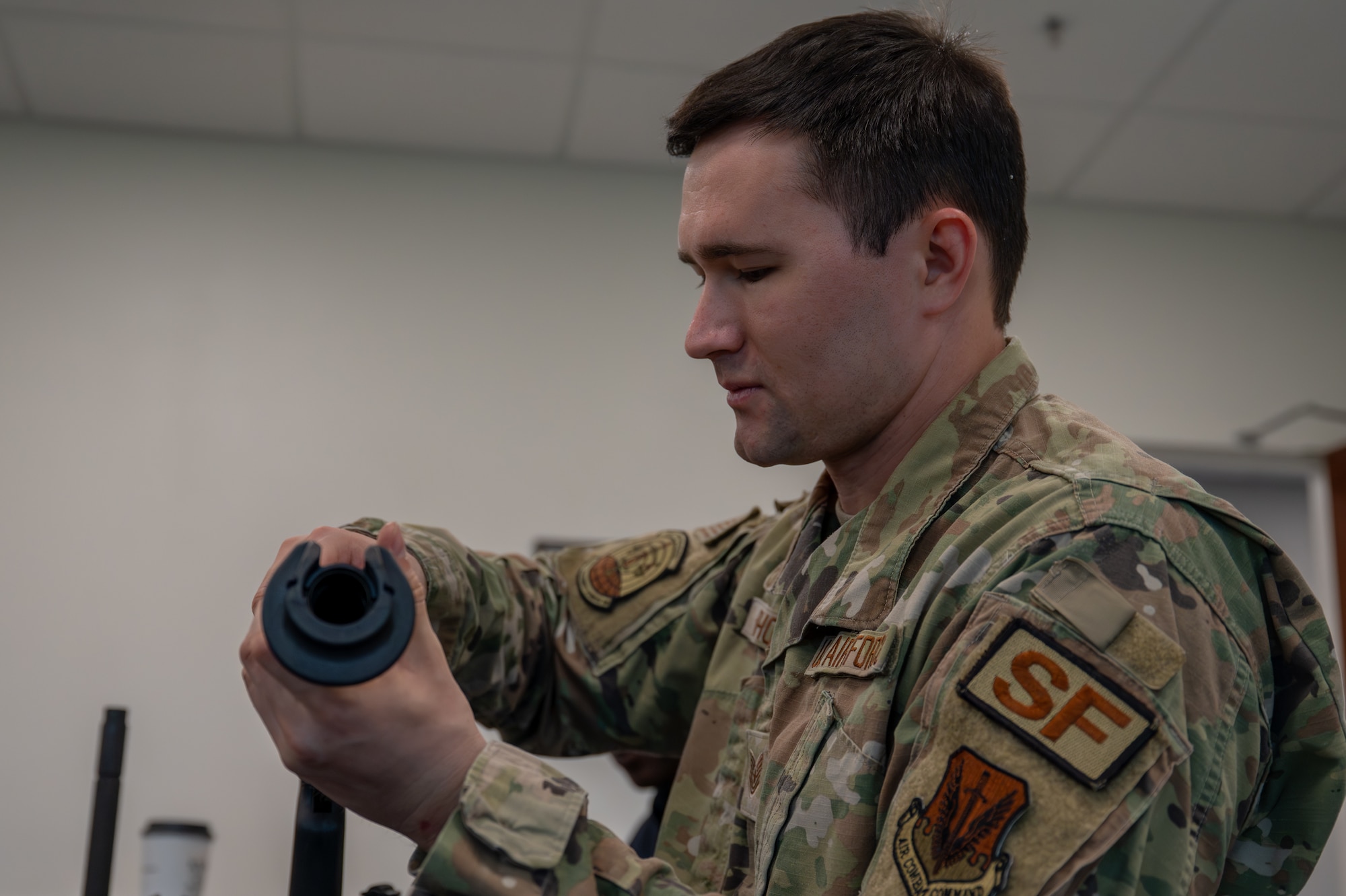U.S. Air Force Tech. Sgt. Nicholas Rhoades, 325th Security Forces Squadron training and standardization section chief, inspects the barrel of an M870 shotgun during a combat arms training and maintenance class at Tyndall Air Force Base, Florida, May 21, 2026. The training course taught weapon safety, operator maintenance and the fundamentals of controlling the weapon's spread. (U.S. Air Force photo by Airman 1st Class Rosario Garcia)