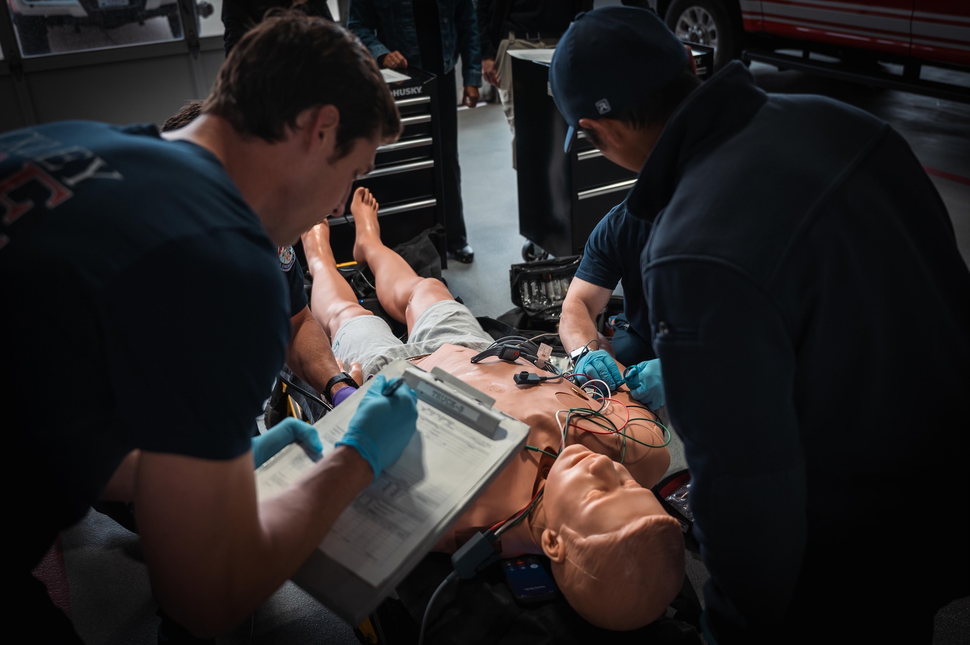 Paramedics take vitals from a trauma mannequin