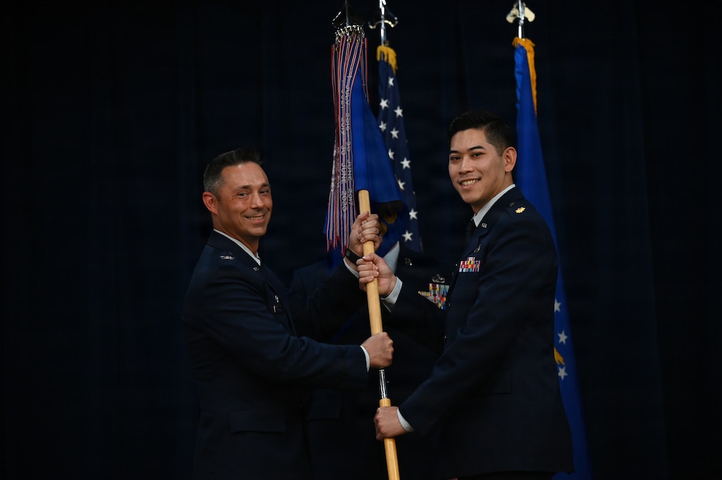 U.S. Air Force Col. Darryl Hebert, 56th Mission Support Group commander, passes the guidon to Maj. Alexander Siangpipop, incoming 56th Contracting Squadron commander, at Luke Air Force Base, Arizona, May 27, 2026. The ceremony symbolized the transfer of authority as Siangpipop assumed command of the 56th CONS, supporting the 56th Fighter Wing’s rapid modernization and advanced F-35A Lightning II training standards, projecting unmatched U.S. power worldwide. (U.S. Air Force photo by Staff Sgt. Magen M. Reeves)