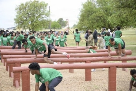 Student-athletes from Ellison High School in Killeen, Texas, jump over and duck under the over-under obstacle during the Basic Training Challenge at the U.S. Army Experience March 25, 2026, at Fort Hood, Texas.