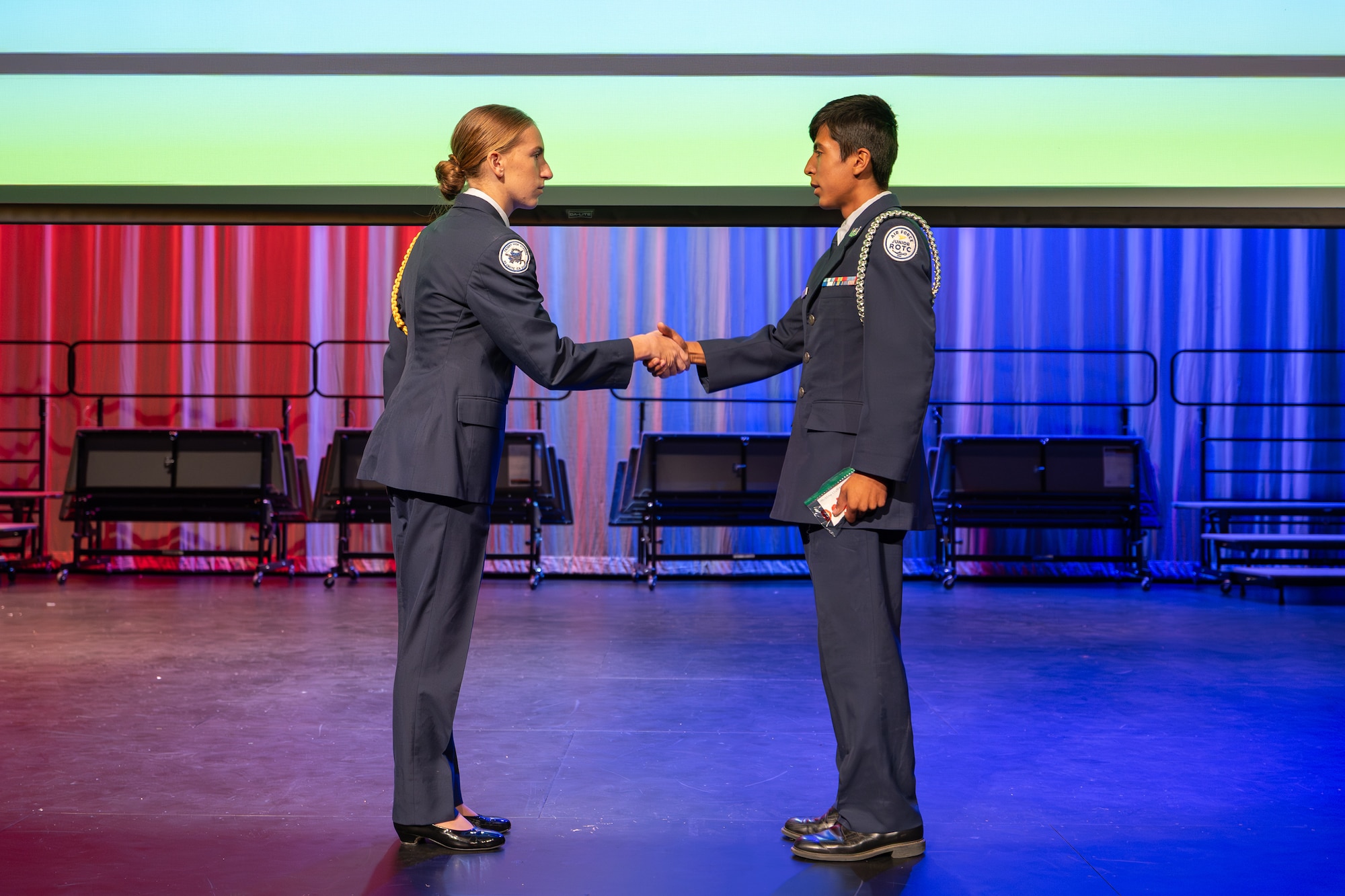 Cadet Maj. Beverly Praiswater, Air Force Junior ROTC commander, shakes hands with Cadet Airman Joshua Delgado during the annual Air Force Junior ROTC ceremony at Desert Junior-Senior High School on Edwards Air Force Base, Calif., May 28. Delgado received his new rank insignia during the event. (U.S. Air Force photo by Christian Raterman)