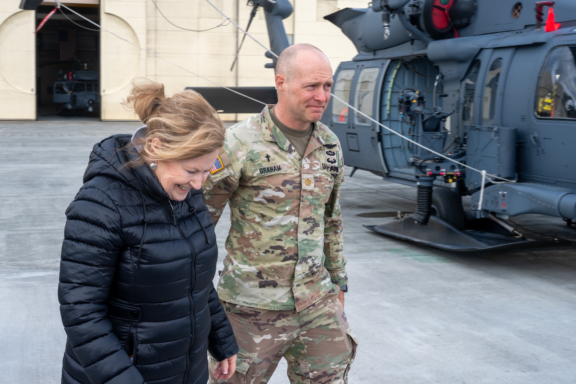 U.S. Army Chaplain (Maj.) Jon Graham, assigned to the 2nd Infantry Brigade Combat Team (Airborne), 11th Airborne Division, walks alongside a member of a Gold Star family during a tour of the 176th Wing at Joint Base Elmendorf-Richardson, Alaska, May 21, 2026. The event provided an opportunity for personal connection, reinforcing the community bonds built throughout the multi-unit installation tour. This joint-base event brought together Army and Air Force personnel to offer support, fellowship and technical insight to families of fallen service members. (U.S. Air Force photo by Airman 1st Class Theodore Gowdy)