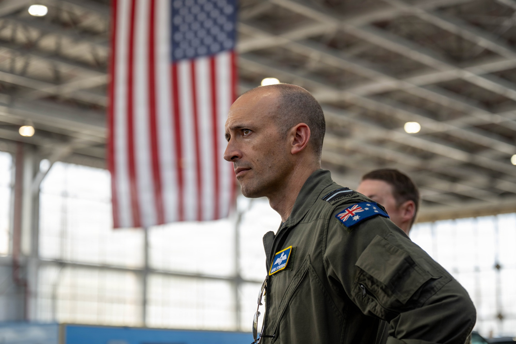 Royal Australian Air Force Air Vice-Marshal David Titheridge, Pacific Air Forces deputy commander, listens to Airmen brief during a tour at Joint Base Pearl Harbor-Hickam, May 19, 2026. The tour immersed Titheridge in the 15th Wing mission set, providing firsthand insight into the capabilities and Airmen serving there. (U.S. Air Force photo by Senior Airman Lauren Torres)