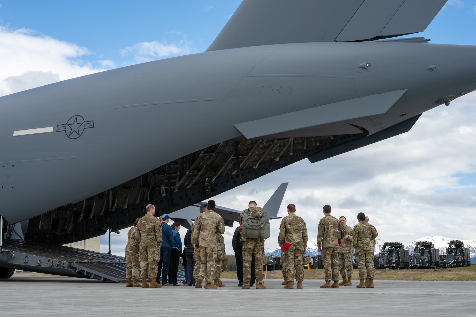 A Gold Star family and tour facilitators gather at the cargo loading ramp of a C-17 Globemaster III aircraft during a 3rd Wing-hosted tour at Joint Base Elmendorf-Richardson, Alaska, May 21, 2026. The wide-area brief highlighted how the strategic transport airframe is configured to rapidly deploy troops, vehicles and heavy equipment worldwide. This joint-base event brought together Army and Air Force personnel to offer support, fellowship and technical insight to families of fallen service members. (U.S. Air Force photo by Airman 1st Class Theodore Gowdy)