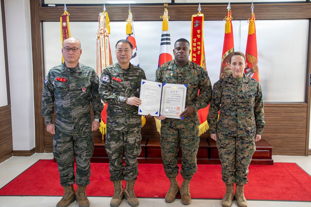 U.S. Marine Corps Maj. Gen. Valerie A. Jackson, Commander of U.S. Marine Corps Forces Korea, and Republic of Korea Marine Corps Lt. Gen. Ju Il-Suk, commandant of the Republic of Korea Marine Corps, pose for a photo with U.S. Marine Corps Sgt. Maj. Ismael G. Bamba, command senior enlisted leader of Marine Forces Korea, and Republic of Korea Marine Corps Sgt. Maj. Jung Hoon Song, sergeant major of the Republic of Korea Marine Corps, during an award ceremony at Republic of Korea Marine Corps Headquarters at Camp Baran, South Korea, Feb. 3, 2026. The commendation highlights significant efforts supporting regional stability, alliance readiness and combined operational effectiveness on the Korean Peninsula. (U.S. Marine Corps photo by Gunnery Sgt. Antonio Campbell)