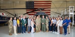 Civic leaders from Travis Air Force Base, California, pose for a group photo with U.S. Airmen inside a helicopter hangar during a visit to Joint Base San Antonio-Lackland, Texas, May 20, 2026. The 37th Training Wing hosted the civic leaders to educate visitors on Air Force training missions and partner capabilities across the installation. (U.S. Air Force photo by Airman 1st Class Ashley Rowell)