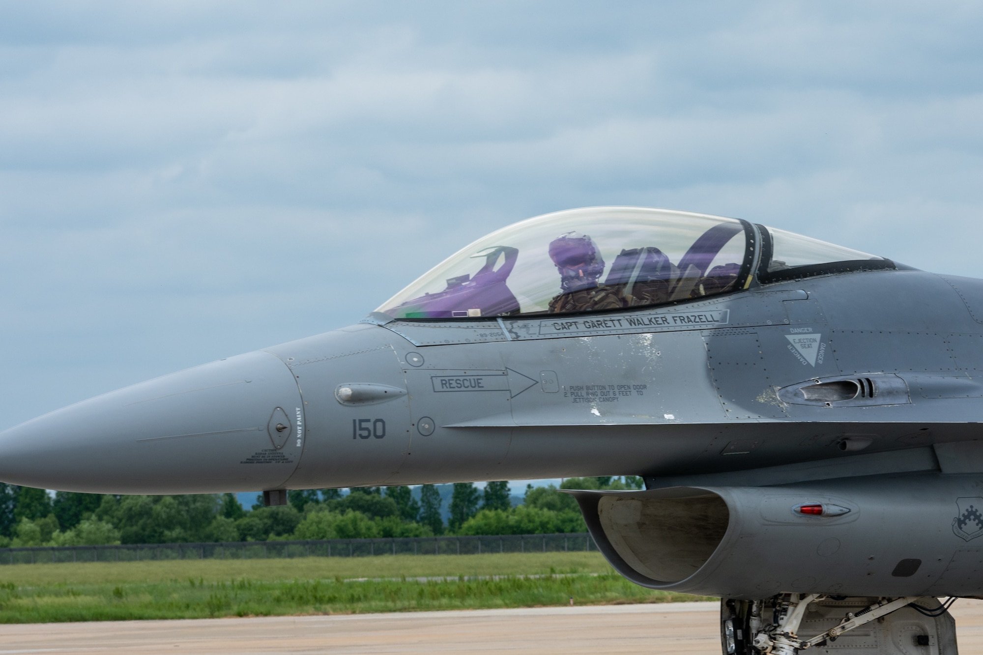 A pilot puts up a hand gesture for a picture as he taxis.