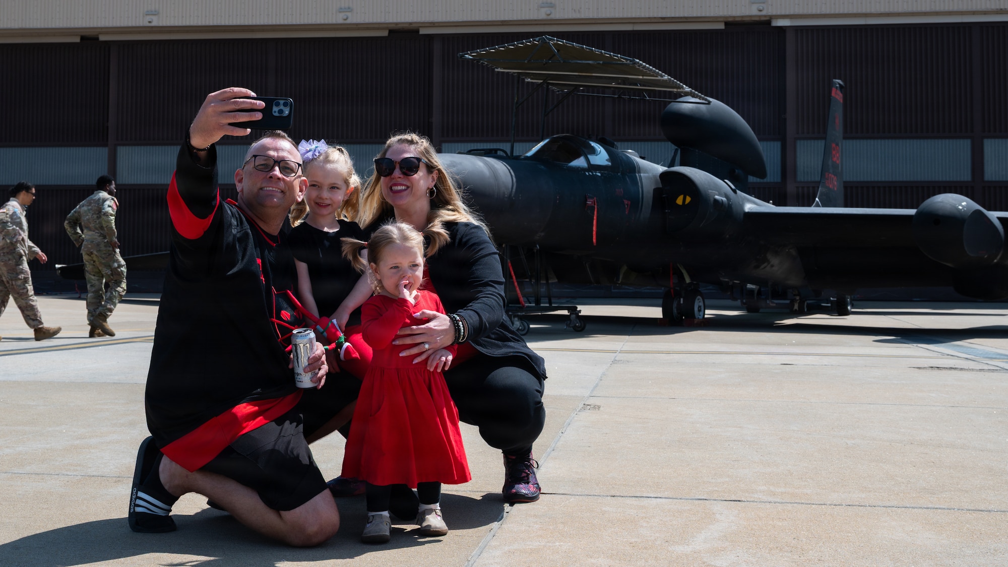 A family takes a photo in front of a plane.