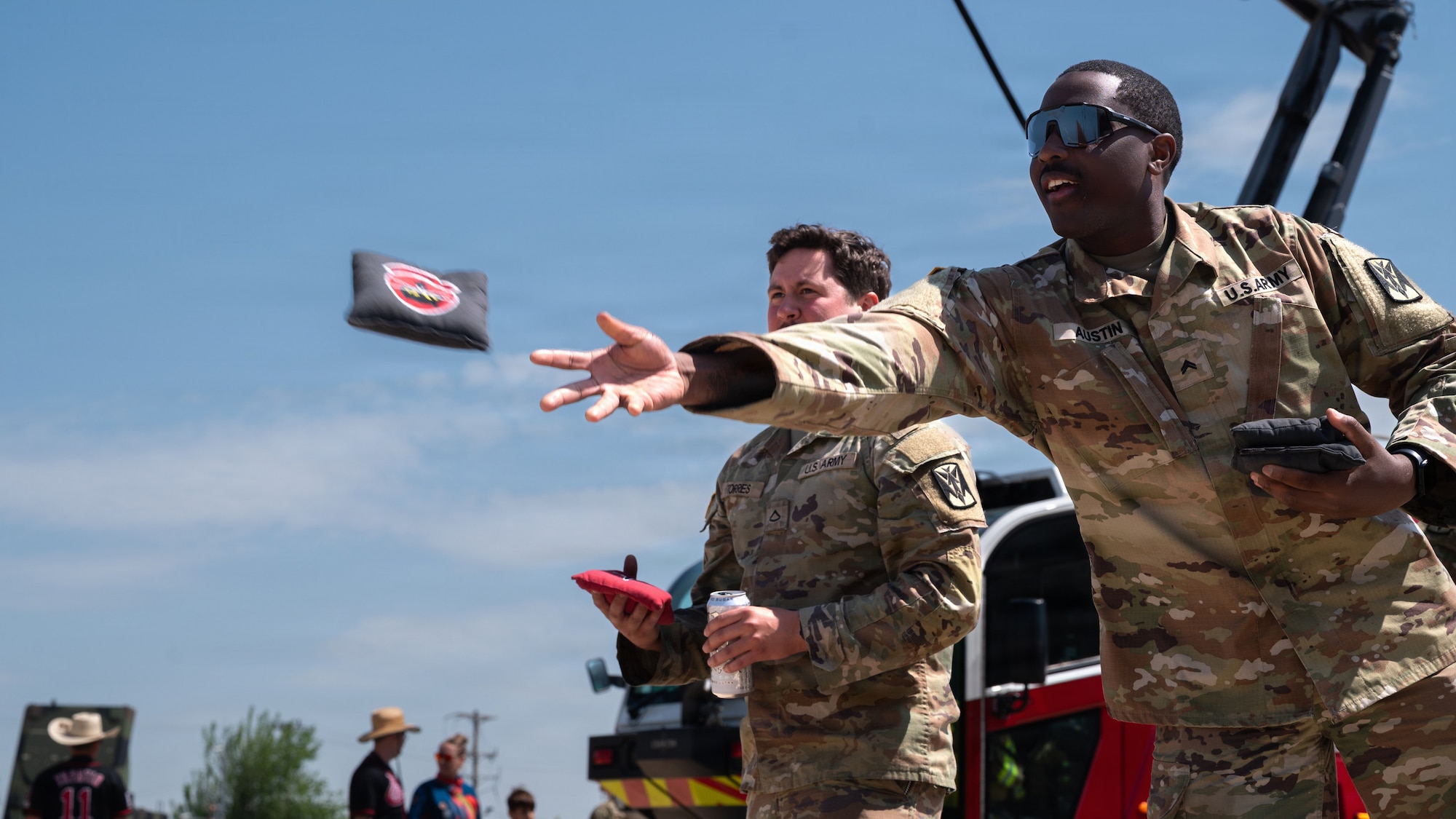 A soldier throws a cornhole bag.