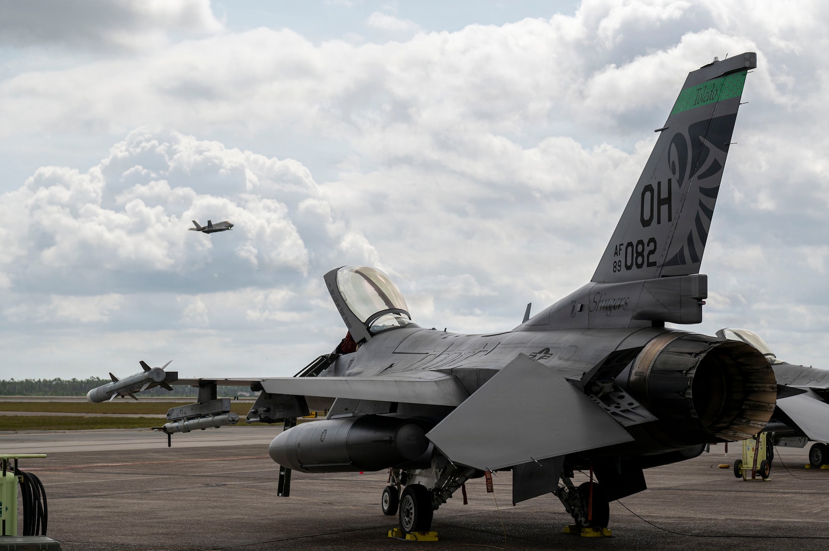 A U.S. Air Force F-16 Fighting Falcon assigned to the Ohio National Guard’s 180th Fighter Wing sits on the flight line as an F-35 Lightning II assigned to the 325th Fighter Wing takes off during Checkered Flag 26-2 and the Weapons System Evaluation Program-East at Tyndall Air Force Base, Fla., April 29, 2026.