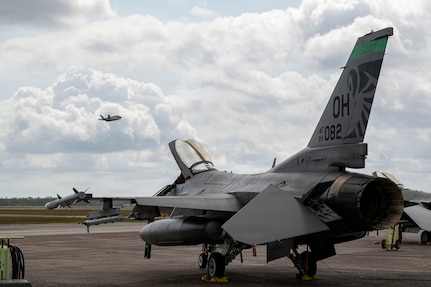 A U.S. Air Force F-16 Fighting Falcon assigned to the Ohio National Guard’s 180th Fighter Wing sits on the flight line as an F-35 Lightning II assigned to the 325th Fighter Wing takes off during Checkered Flag 26-2 and the Weapons System Evaluation Program-East at Tyndall Air Force Base, Fla., April 29, 2026.