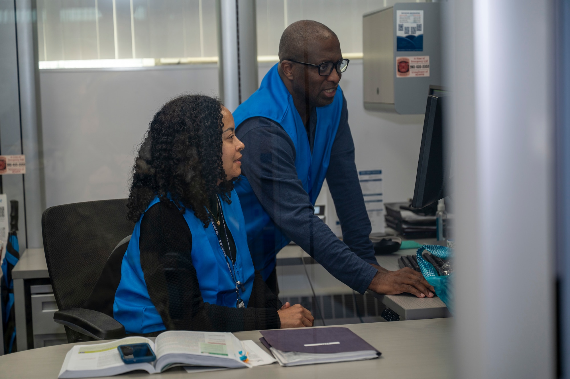 Mr. Basil Forrest, community readiness supervisor assigned to the 11th Force Support Squadron, leads Walkidia Fradera, community readiness consultant with the 11th Force Support Squadron, during a hurricane training event for the emergency family assistance center (EFAC) at Joint Base Anacostia-Bolling, Washington, D.C., April 14, 2026. The EFAC acted as a disaster-response facility providing crisis counseling, financial aid and logistical support to families. (U.S. Air Force photo by Senior Airman Shanel Toussaint)