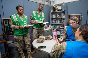 U.S. Air Force members assigned to the 11th Wing Inspection Team observe a member of the 11th Wing Judge Advocate Squadron during a hurricane training event for the emergency family assistance center (EFAC) at Joint Base Anacostia-Bolling, Washington, D.C., on April 14, 2026. The EFAC acted as a disaster-response facility providing crisis counseling, financial aid and logistical support to families. (U.S. Air Force photo by Senior Airman Shanel Toussaint)