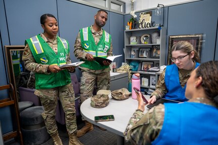U.S. Air Force members assigned to the 11th Wing Inspection Team observe a member of the 11th Wing Judge Advocate Squadron during a hurricane training event for the emergency family assistance center (EFAC) at Joint Base Anacostia-Bolling, Washington, D.C., on April 14, 2026. The EFAC acted as a disaster-response facility providing crisis counseling, financial aid and logistical support to families. (U.S. Air Force photo by Senior Airman Shanel Toussaint)