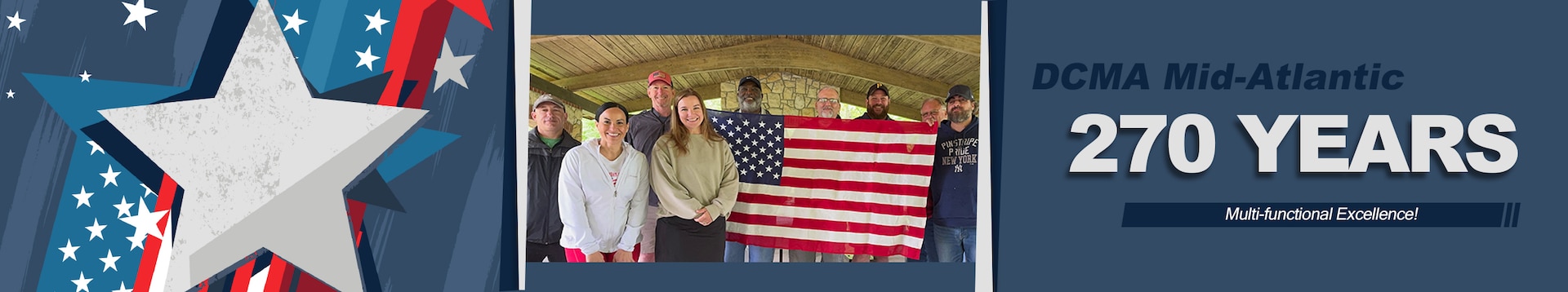 A group poses for a photo outdoors under covered picnic area.