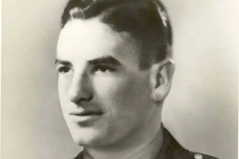 A man is pictured wearing a military dress uniform.