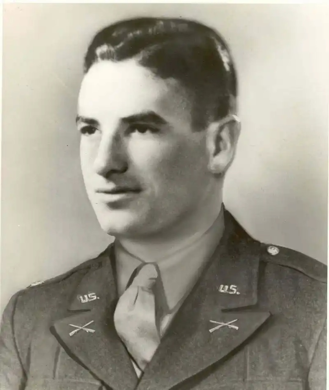 A man is pictured wearing a military dress uniform.