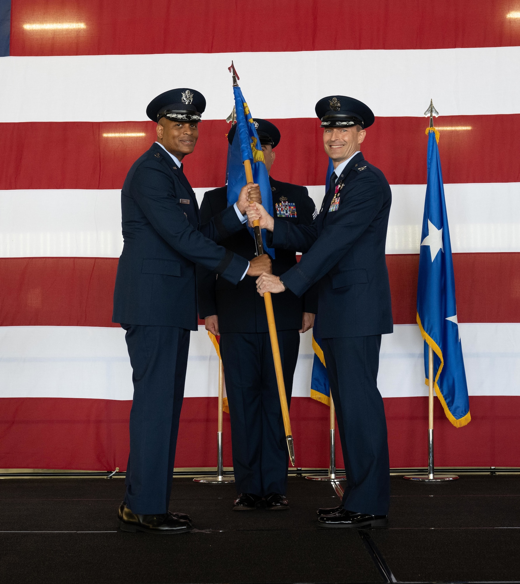 U.S. Air Force Col. Tyler Ellison (left), 47th Flying Training Wing (FTW) former commander, turns over the 47th FTW guidon to Maj. Gen. Roy Collins (right), Air Education and Training Command, deputy commander, during the 47th FTW change of command ceremony at Laughlin Air Force Base, Texas, May 28, 2026. As commander, Ellison oversaw the execution of over 71,000 sorties, successfully producing more than 700 combat ready pilots. (U.S. Air Force photo by Airman 1st Class Harrison Sullivan)