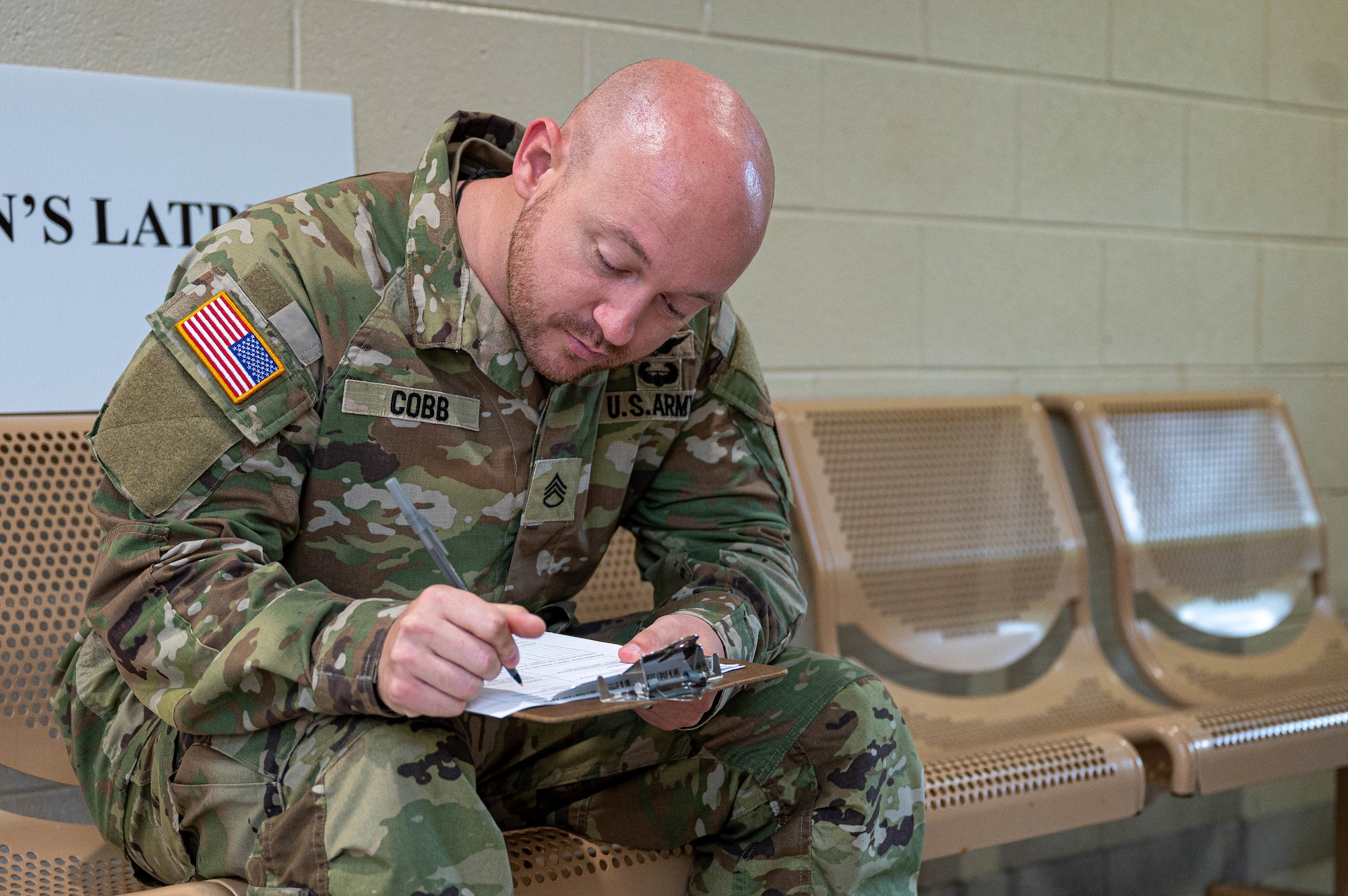 Photo of a solider sitting filling out paperwork.