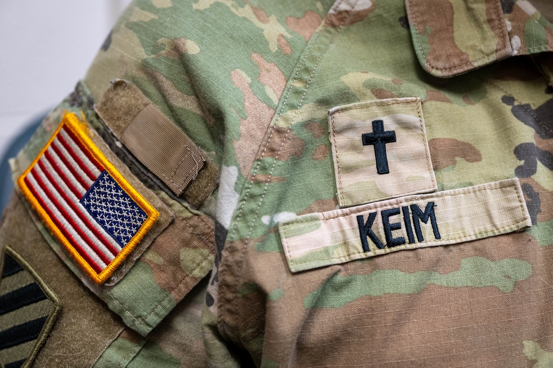 Up close photo of a chaplain's uniform. You can see his name tape, cross, and American flag.