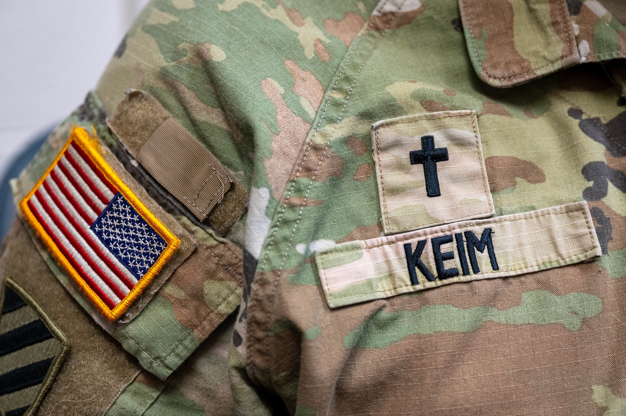 Up close photo of a chaplain's uniform. You can see his name tape, cross, and American flag.