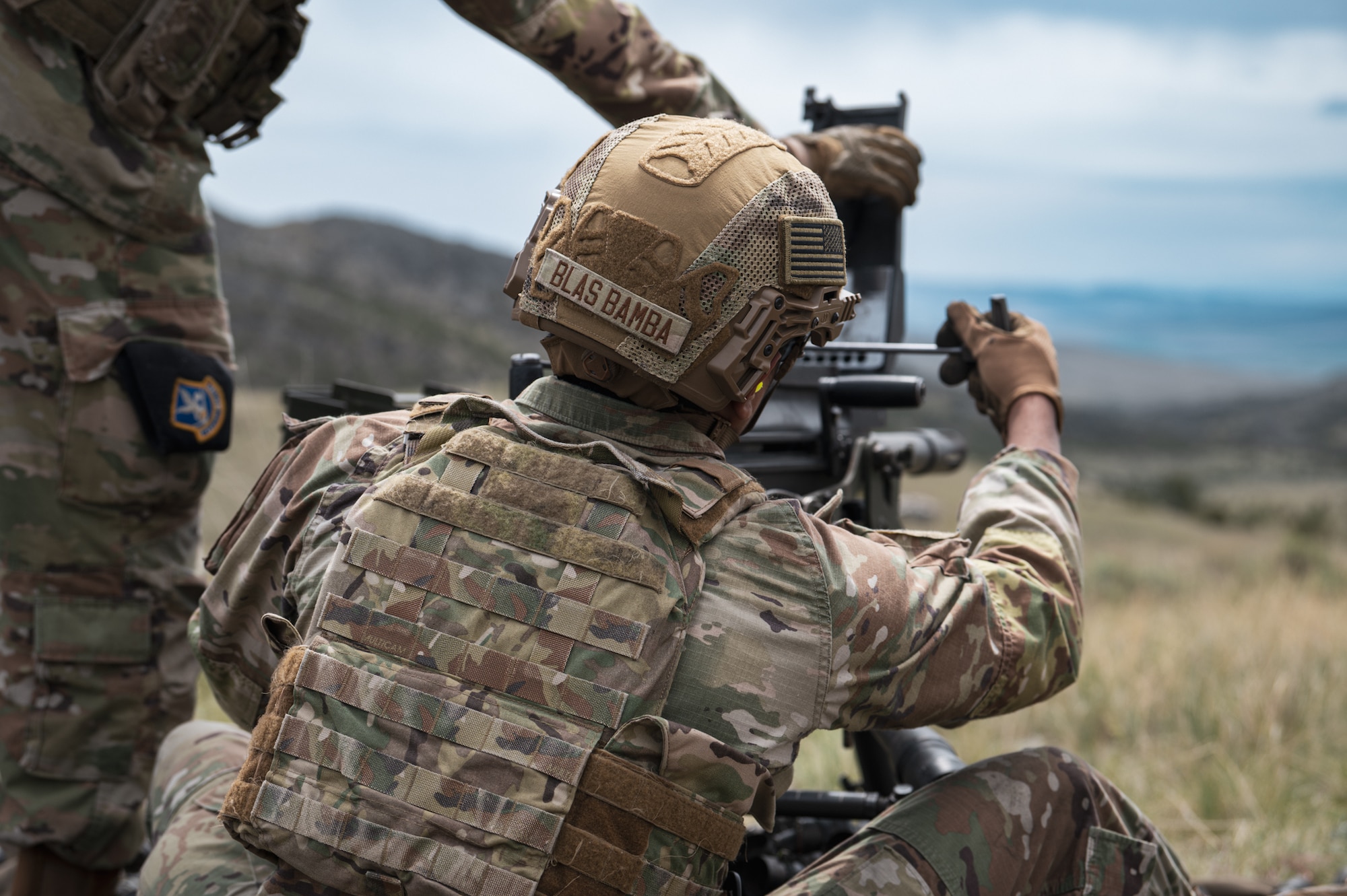 Two uniformed men clear an MK19 grenade launcher.