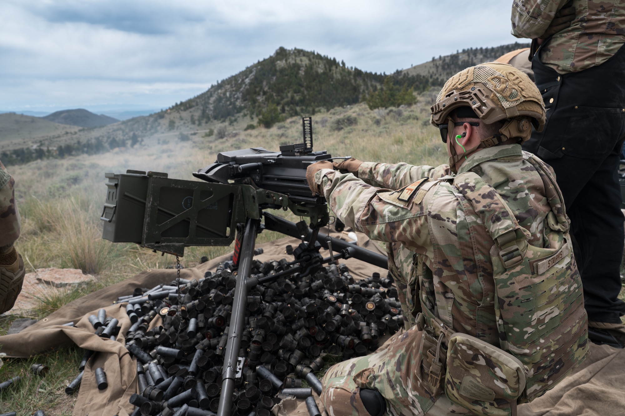 A uniformed man fires a Mk 19 grenade launcher.