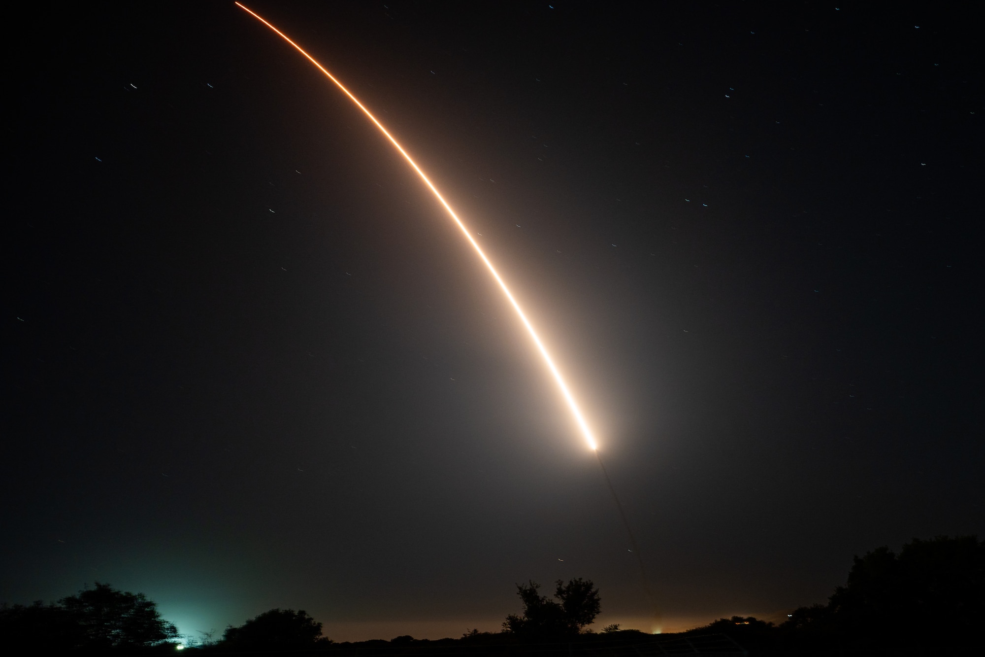 A missile shooting through the night sky.