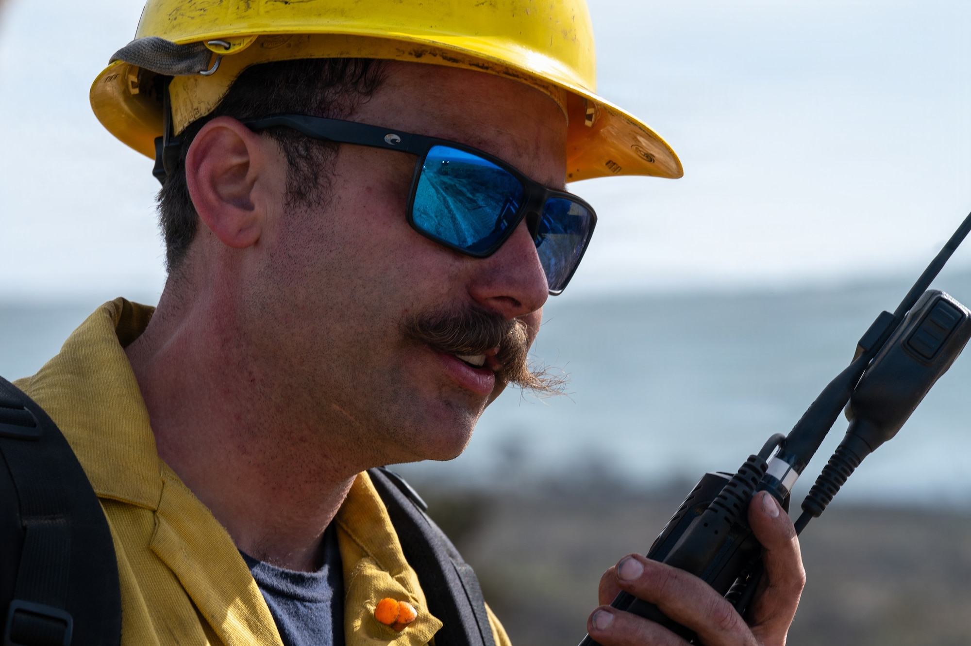 Man holds a radio and talks into it.