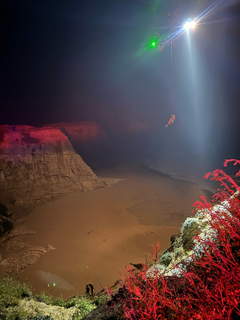 A U.S. Coast Guard Air Station San Francisco MH-65 Dolphin aircrew rescues three people from a cave near Santa Cruz, California, May 17, 2026.  Air crew members hoisted all three individuals and transferred them to the care of nearby CAL FIRE and Santa Cruz County Fire personnel for further evaluation. (U.S. Coast Guard photo by Petty Officer 2nd Class Thomas Sizer)