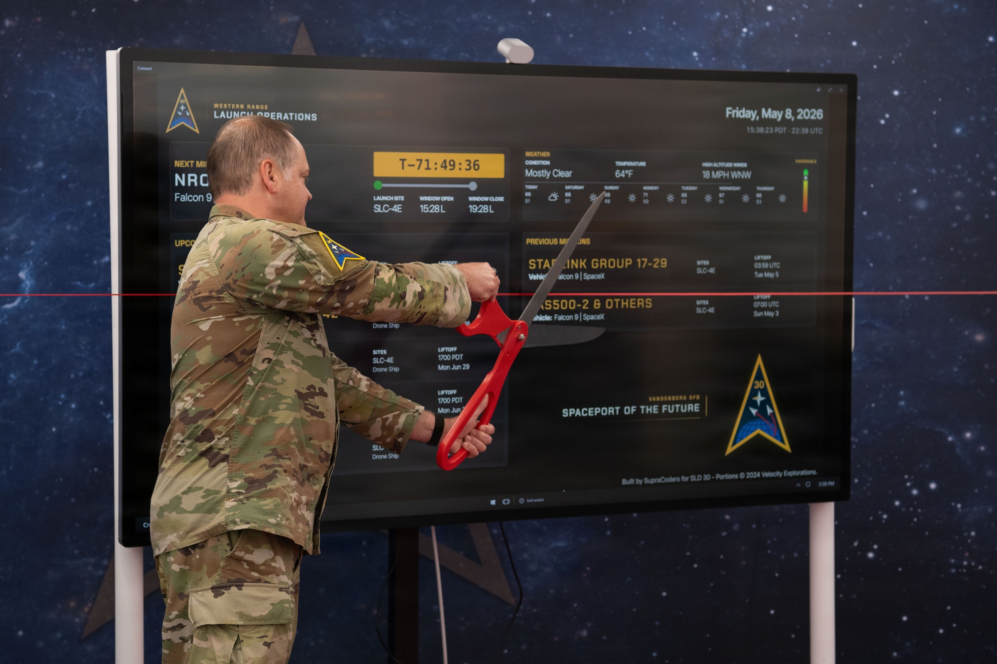 U.S. Space Force Col. James T. Horne III, Space Launch Delta 30 commander cuts a ribbon celebrating a new on-base Vandenberg Launch Dashboard at Vandenberg Space Force Base, Calif., May 8, 2026. The Vandenberg Launch Dashboard was created by SLD 30’s Digital Transformation Office to share upcoming Vandenberg launches with the base population. The dashboard is now active at the Pacific Coast Center for on-base launch schedule awareness. (U.S. Space Force photo by 2nd Lt. Andrew Taller)