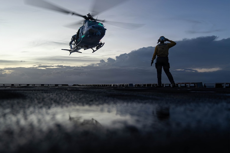 A U.S. Sailor assigned to the San Antonio-class amphibious transport dock USS Fort Lauderdale (LPD 28) gives a send-off salute as a U.S. Marine Corps UH-1Y Venom  assigned to Marine Medium Tiltrotor Squadron (VMM) 365 (Reinforced), Littoral Combat Force-24, takes off during night deck landing qualifications while underway in the Caribbean Sea, May 19, 2026. U.S. military forces are deployed to the U.S. Southern Command area of responsibility in support of Operation SOUTHERN SPEAR, Department of War-directed operations, and the president’s priorities to disrupt illicit drug trafficking, deter malign actors and protect the homeland through continuous presence. (U.S. Marine Corps photo)