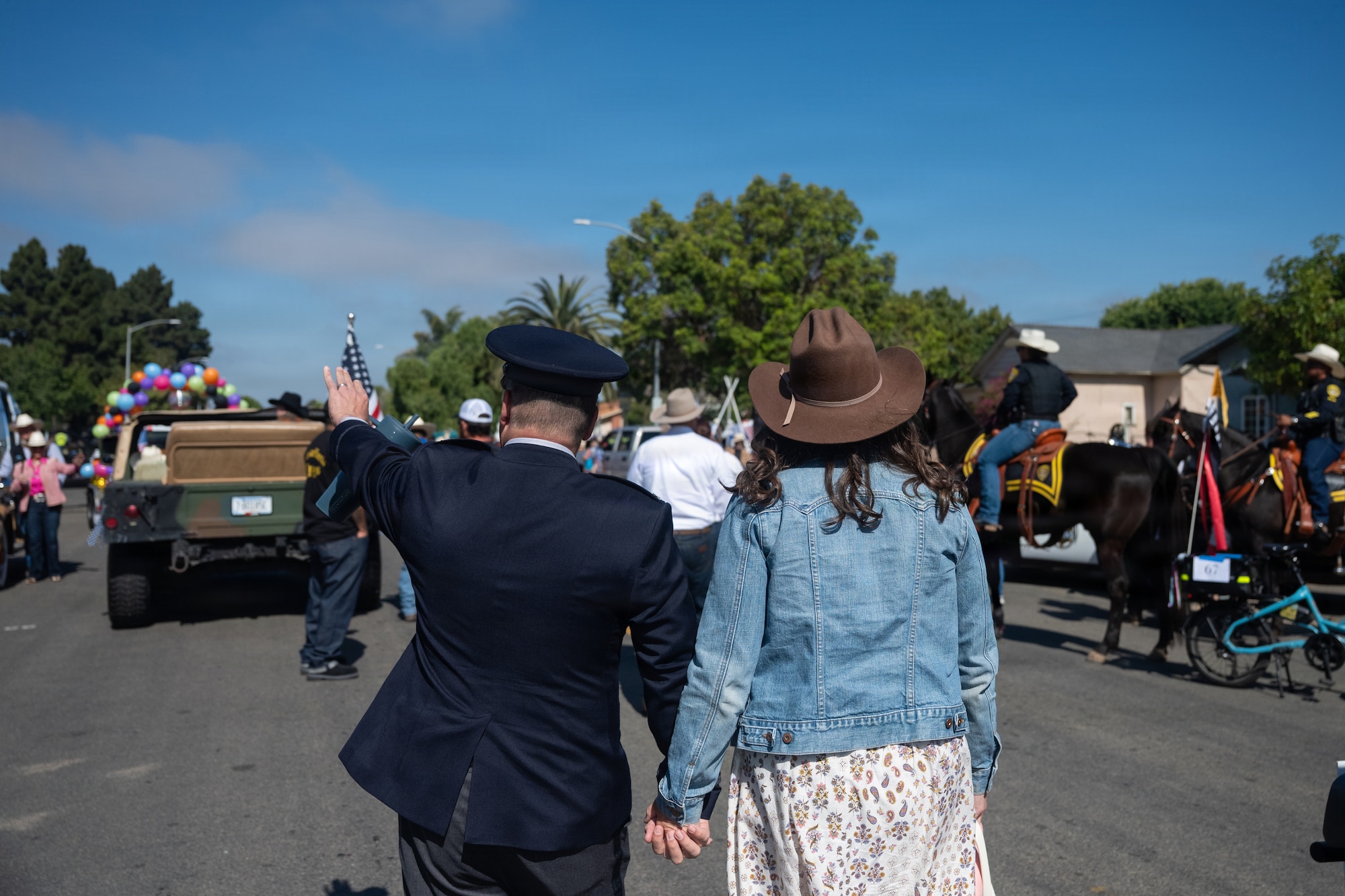 Man and woman hold hands walking down the street.