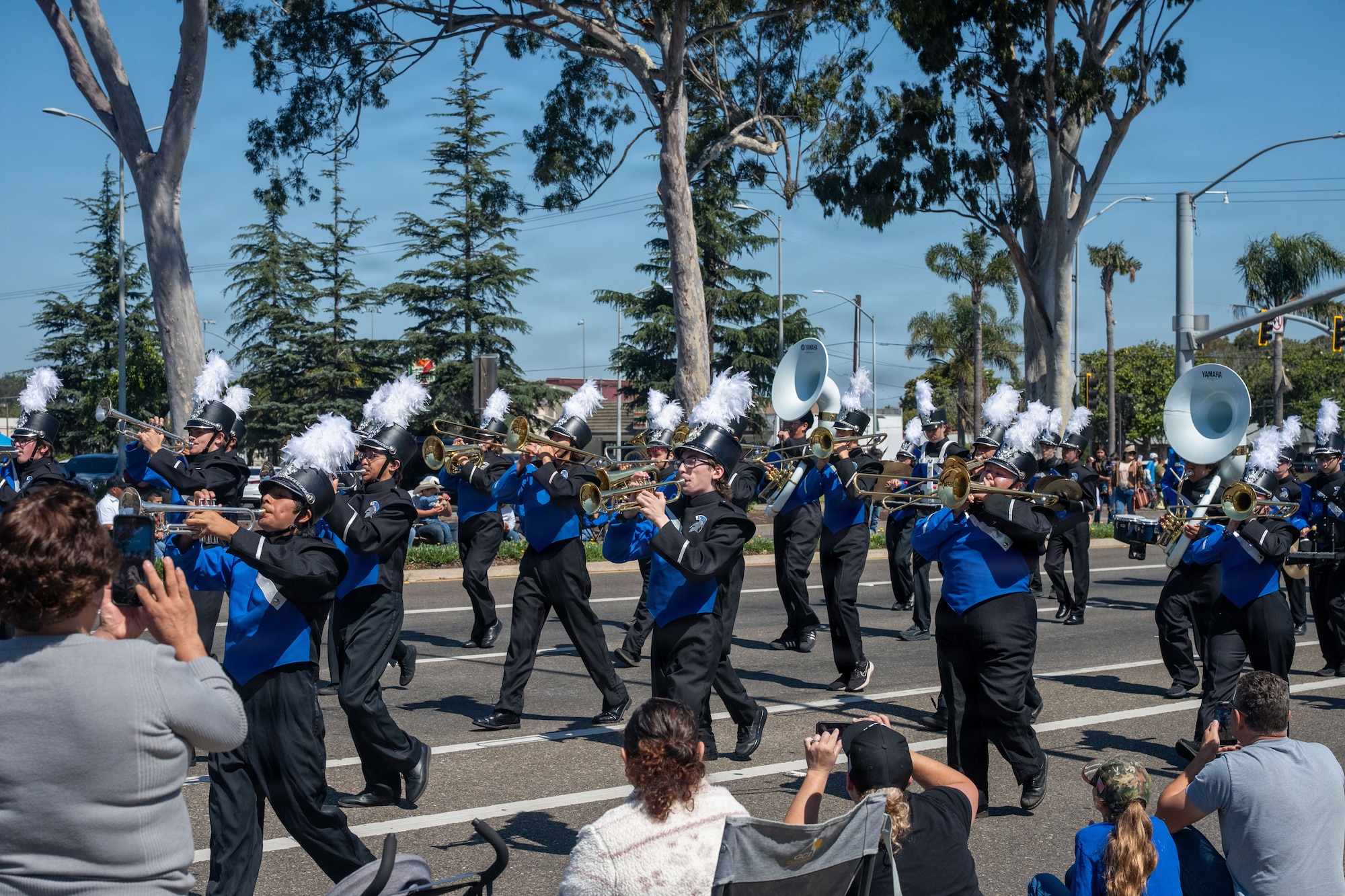 High school marching band play instruments in the street.