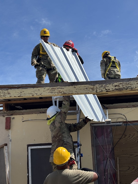 Army soldiers working on a roof.