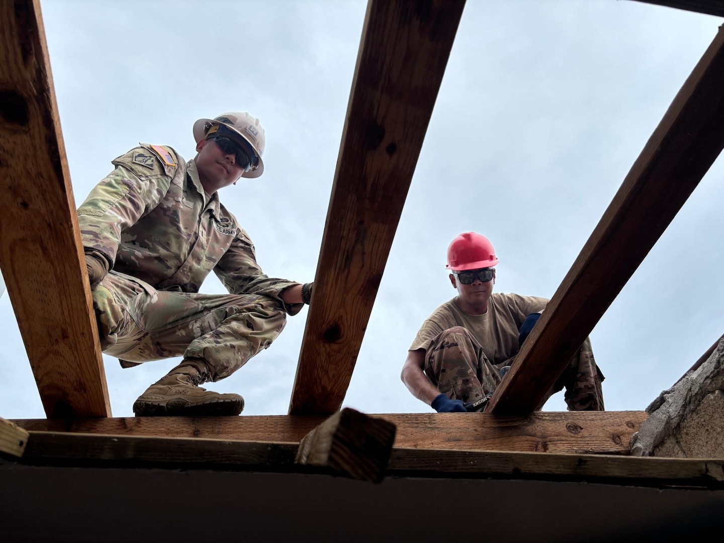 Two Army Reserve soldiers on the roof working.