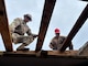 Two Army Reserve soldiers on the roof working.