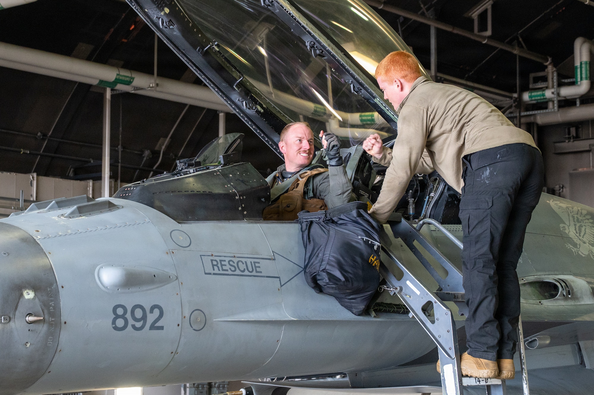 U.S. Air Force Capt. Kinser “Hawc” Newkirk, left, 14th Fighter Squadron F-16 Fighting Falcon pilot, fist bumps Airman Oliver Roe, 14th Fighter Generation Squadron crew chief