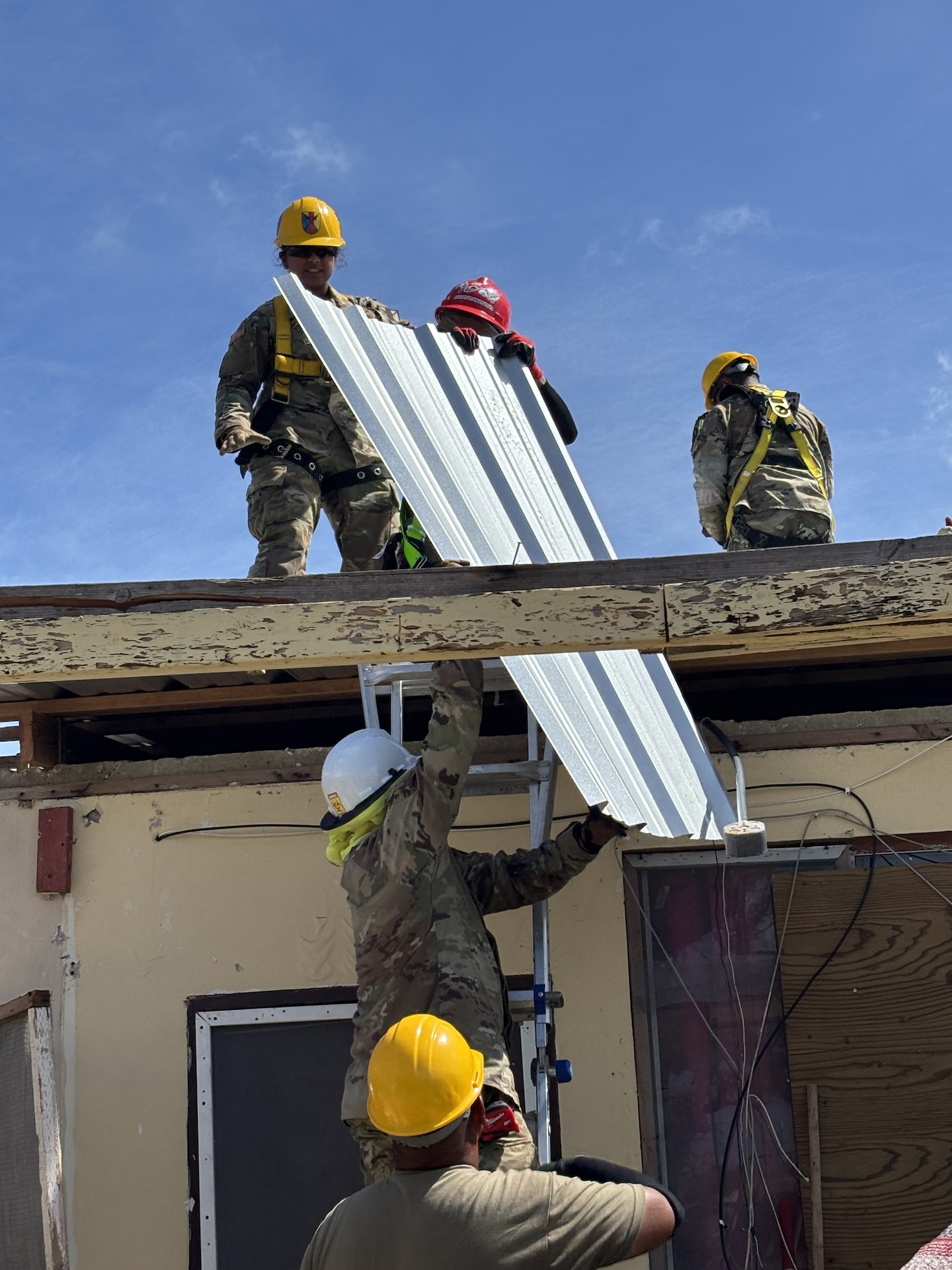 Army soldiers working on a roof.
