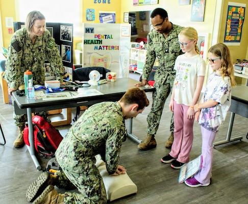 Hospital Corpsman 2nd Class Daniel Strunk, a Radiology Technician, guides local homeschool students through an interactive medical demonstration as students look on alongside Hospital Corpsman 1st Class Sandra Zdunowski (left) and Hospital Corpsman 3rd Class Kerby Maurice (right), both serving as Biomedical Equipment Technicians (BMETs), during the Homeschool Share Fair at the Naval Air Station Patuxent River Youth Center. Personnel hosted hands-on stations showcasing dental hygiene, basic first aid, and specialized technical fields to engage military families and foster curiosity about healthcare and naval service. Coordinated by NAS Patuxent River School Liaison Officer Dawn Simpson, the event connected local homeschooling families with base resources and support services.