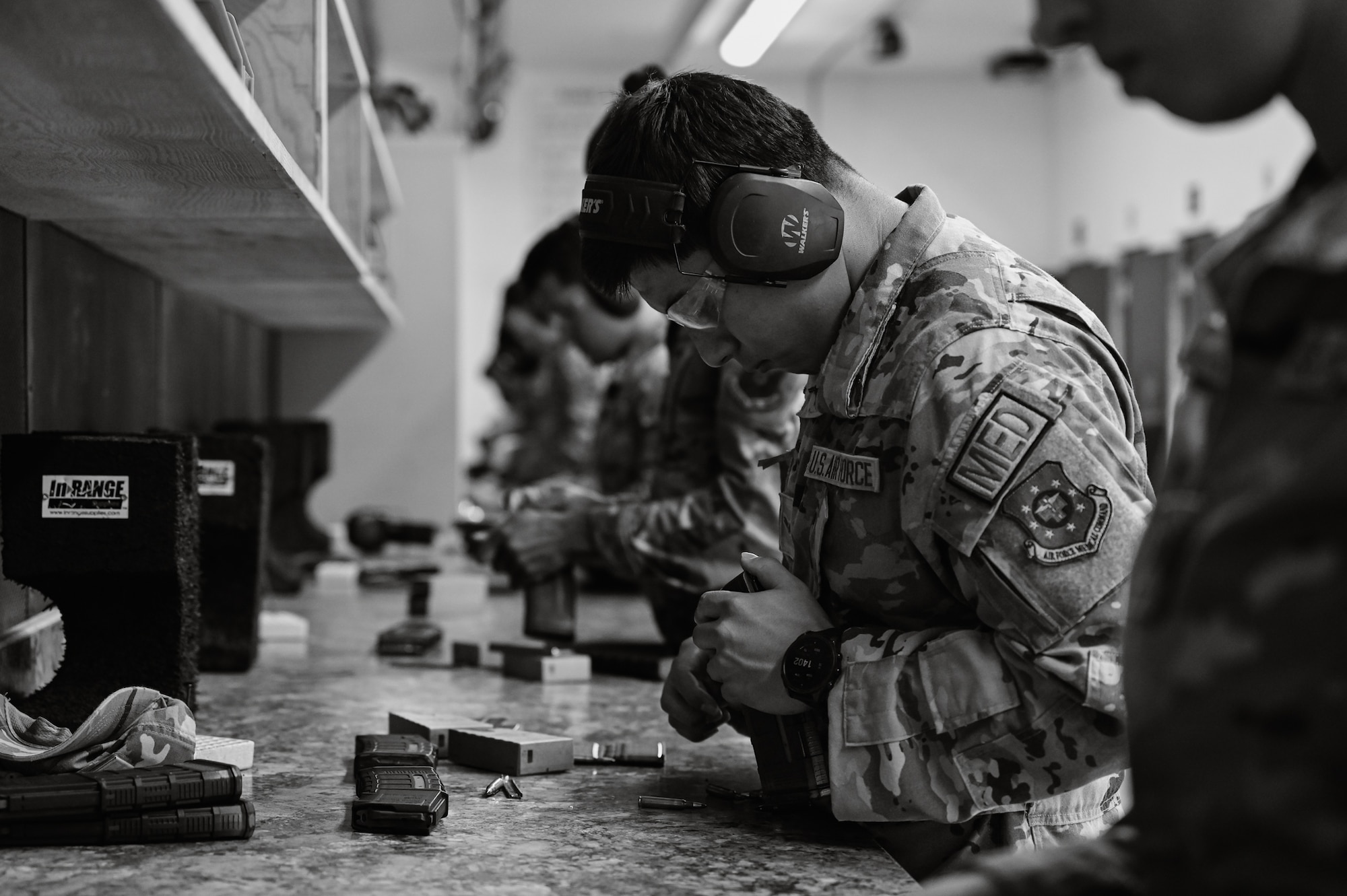 A U.S. Air Force service member loads ammunition into a magazine.