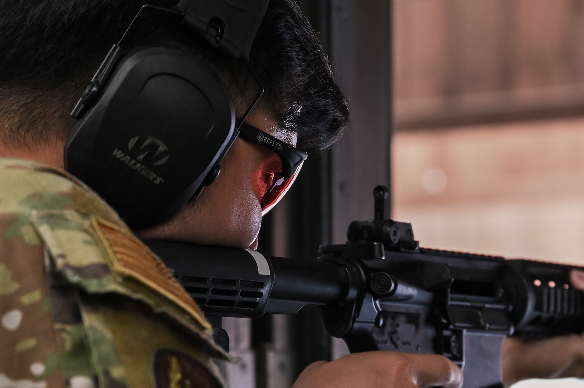 A U.S. Air Force service member fires an M4 carbine.